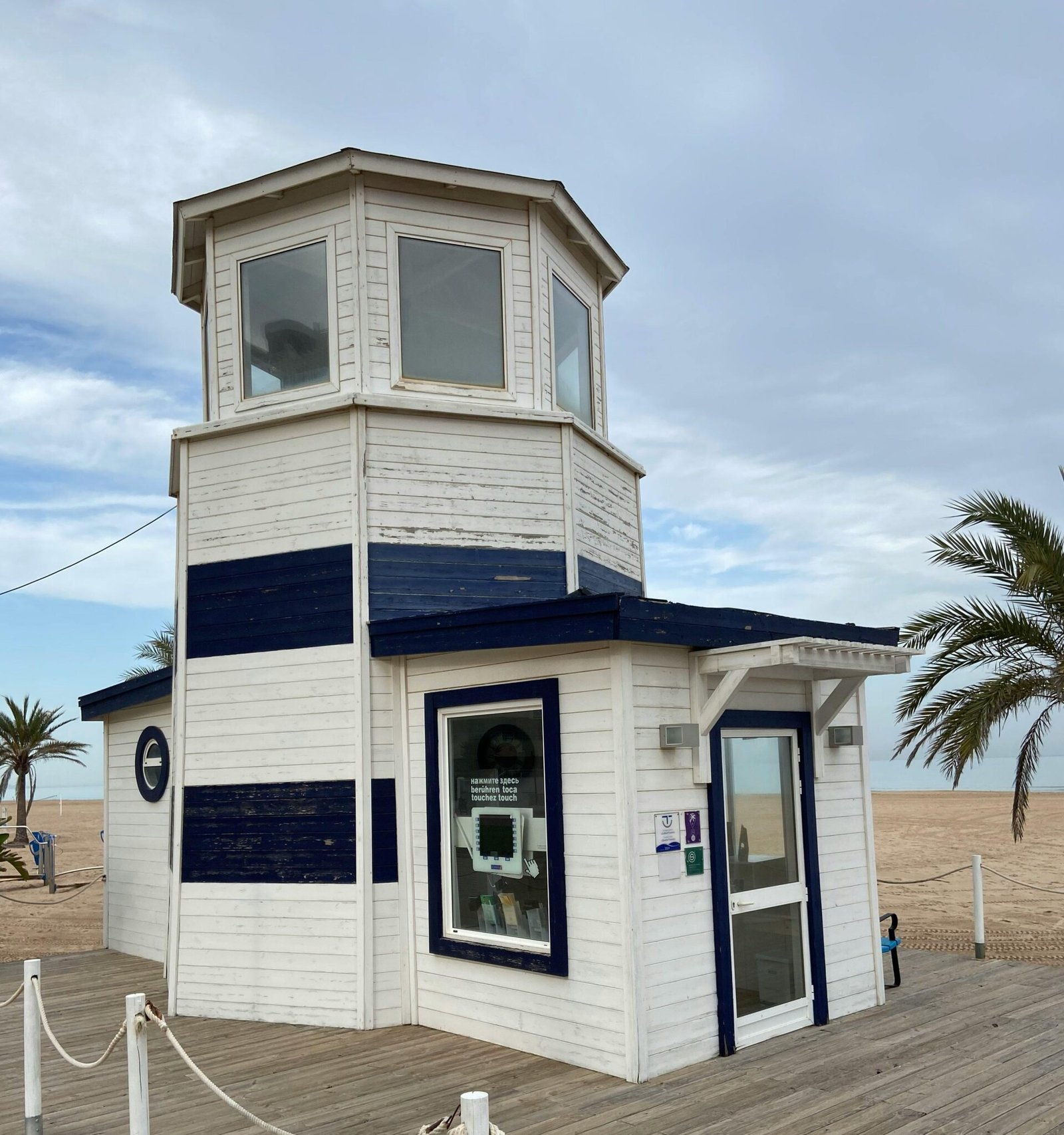 Charming white beach building at Playa de Gandía on a cloudy day, Valencia, Spain.