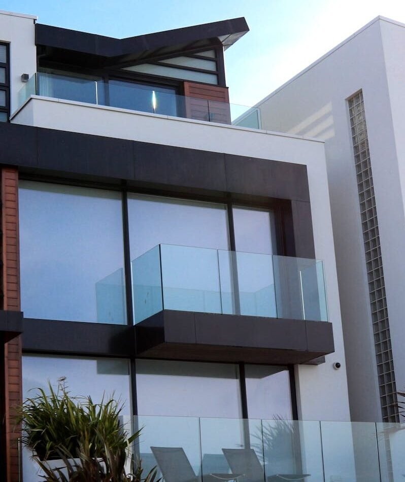 Contemporary luxury home with glass balconies in Poole, UK, showcasing modern architectural design.